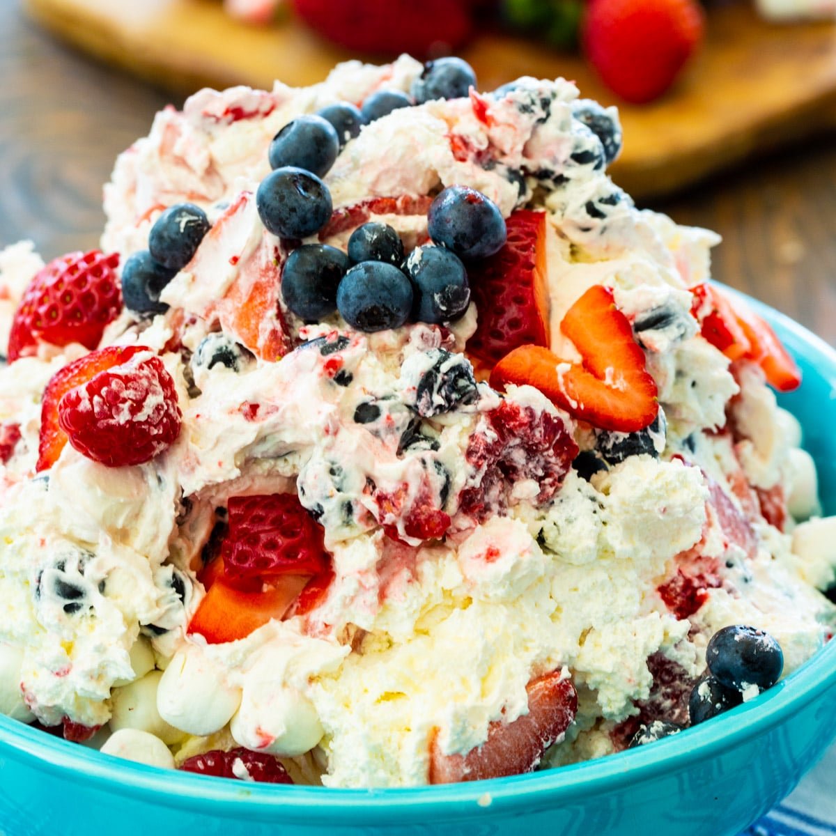 Red, White & Blue Cheesecake Salad in a blue bowl.