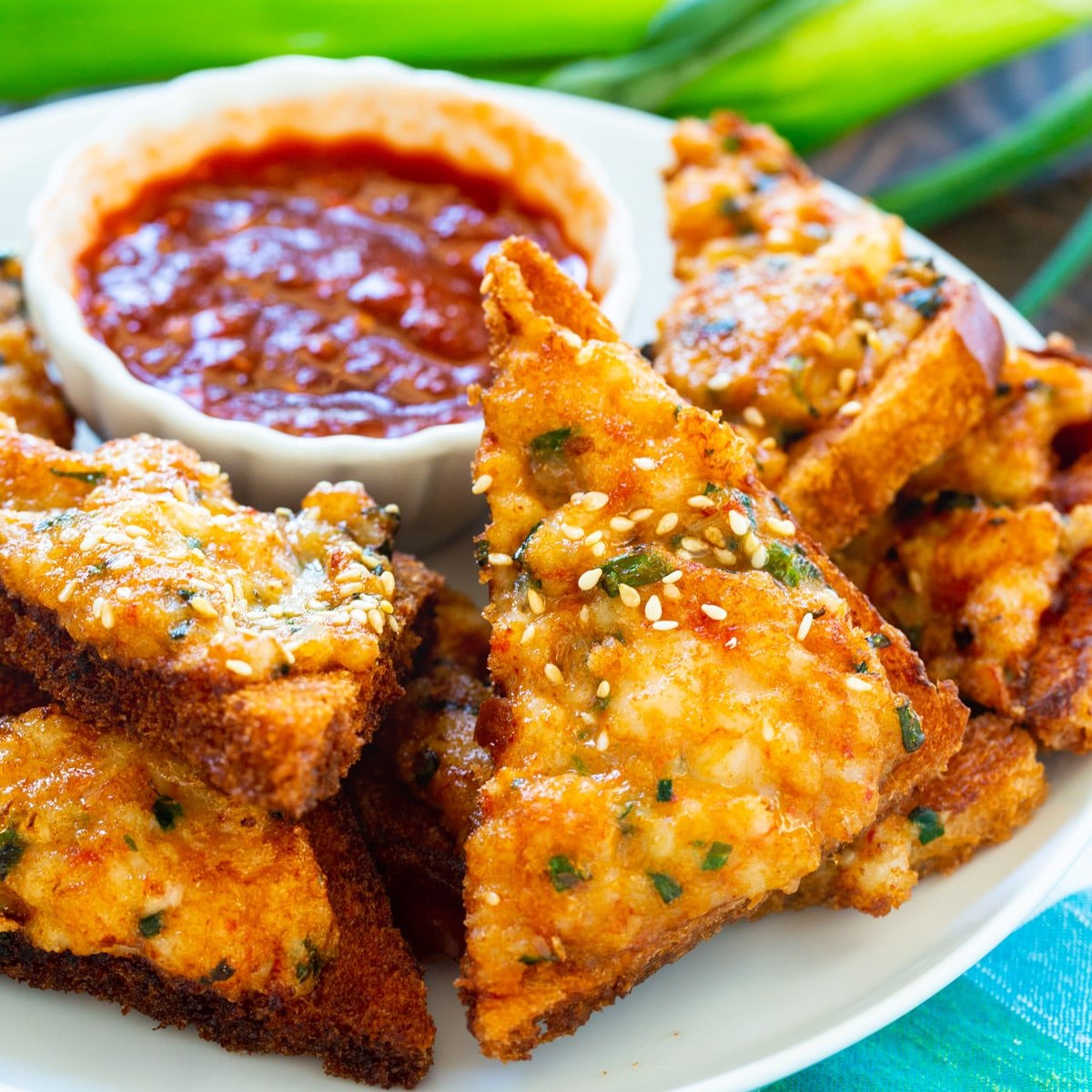 Shrimp Toast on a plate with Chili Garlic Sauce.