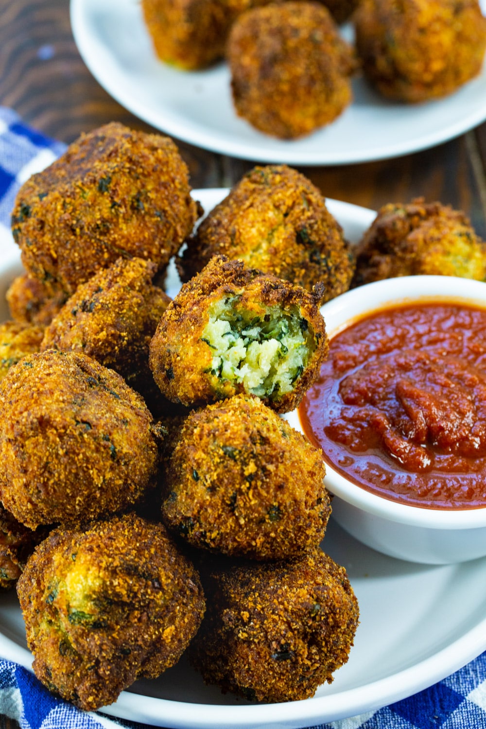 Spinach Cheese Balls on a plate with small bowl of sauce.