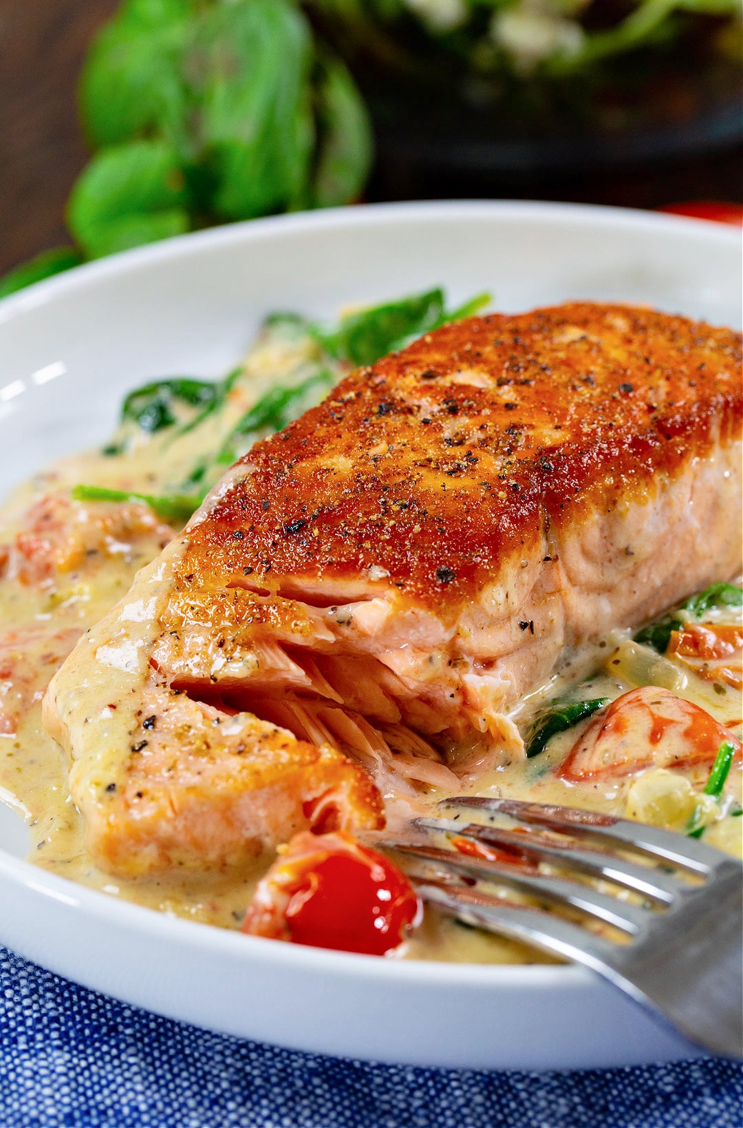 Fork cutting into piece of salmon.