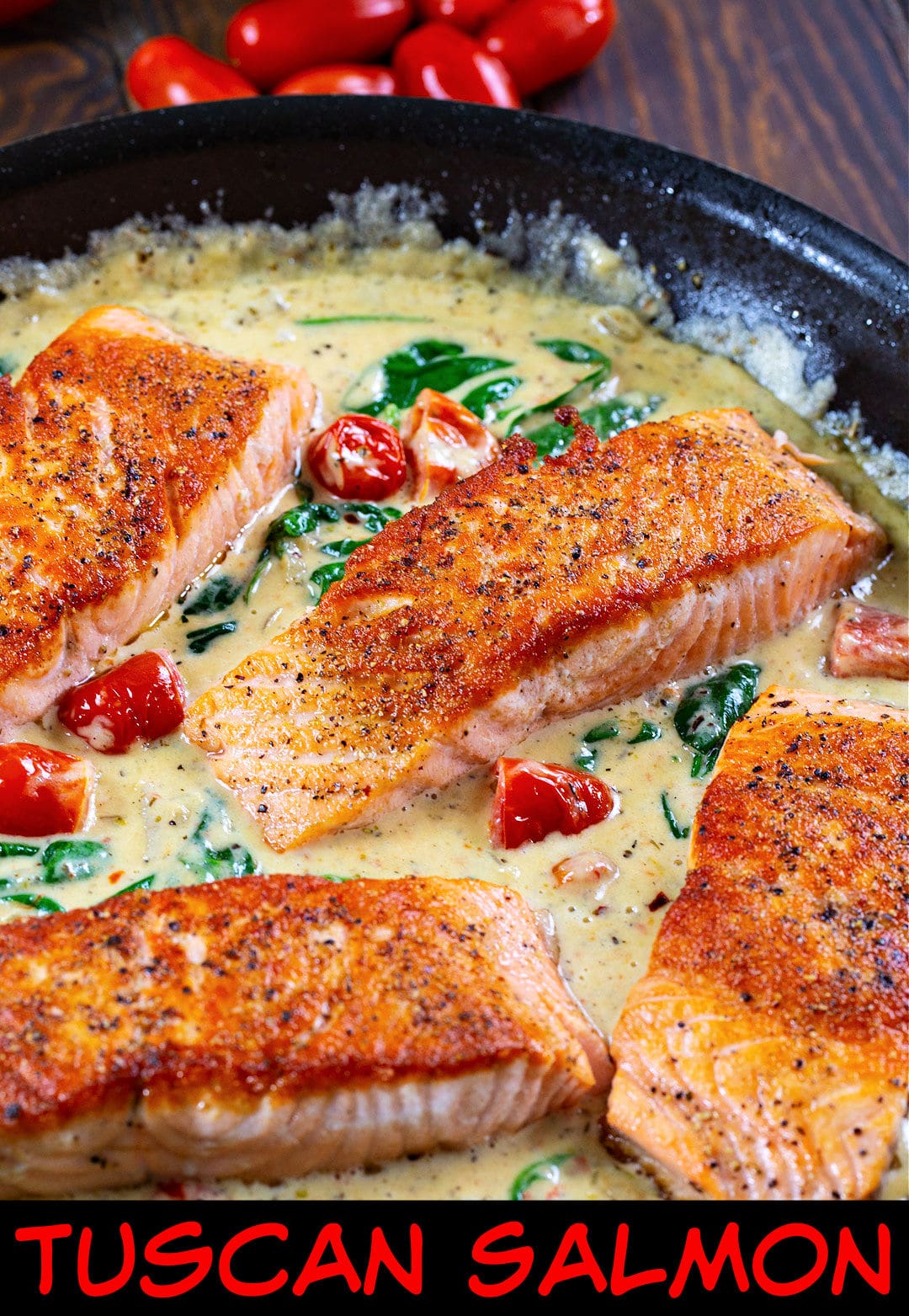Tuscan Salmon fillets in skillet with creamy sauce.