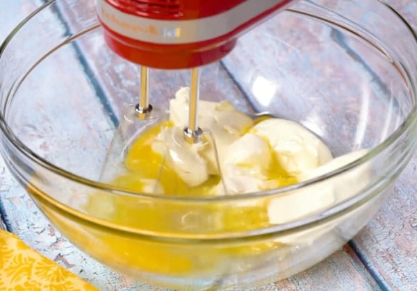 Beating cream cheese and eggs.