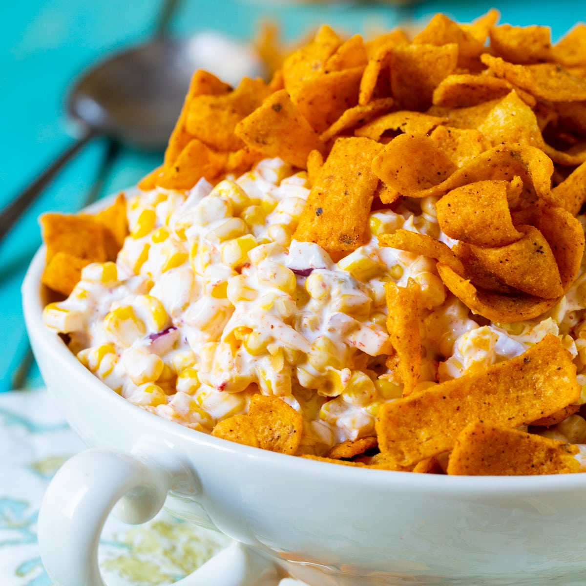 Frito Corn Salad topped with frito chips in a serving bowl.