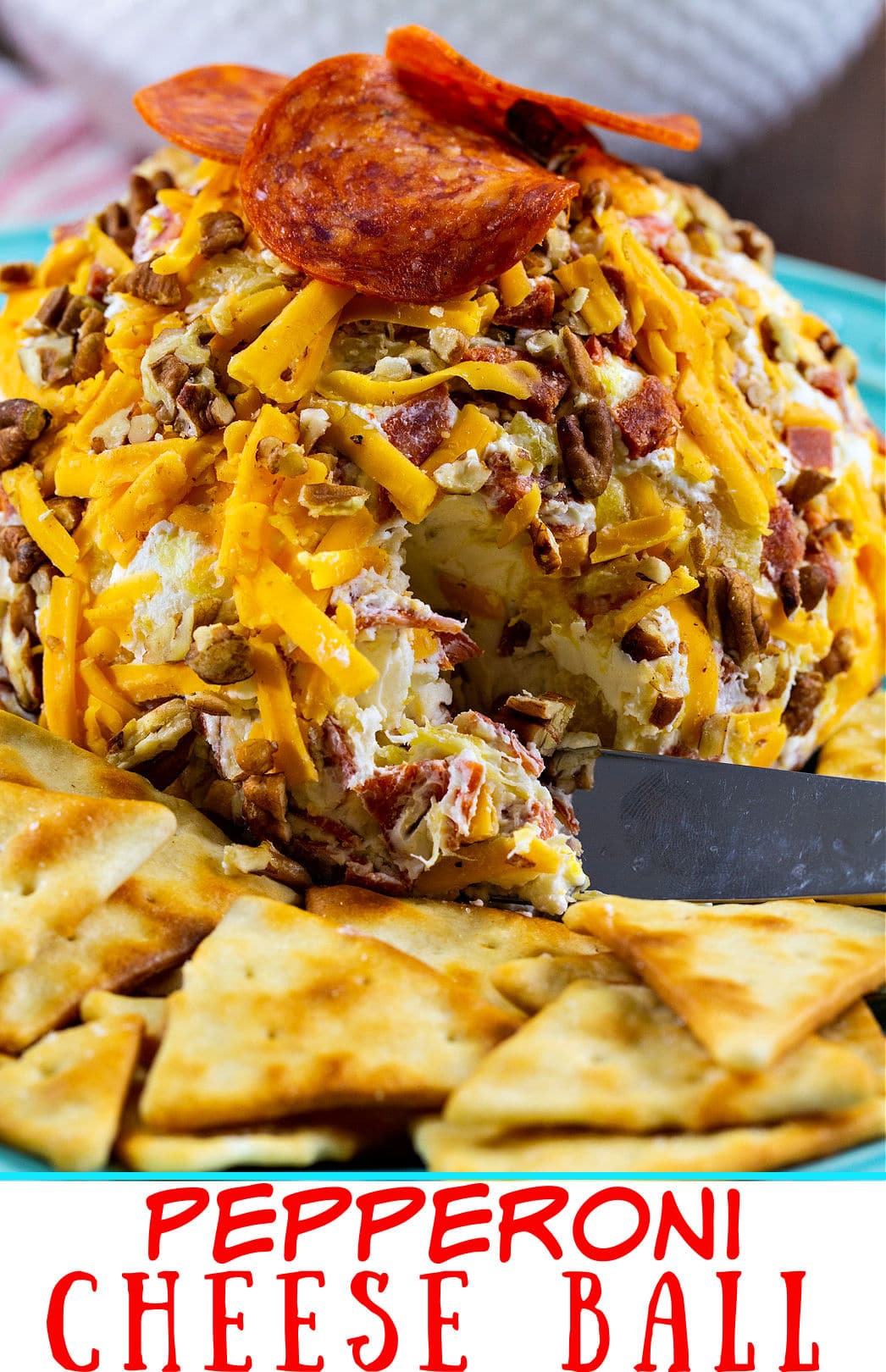 Knife cutting into cheese ball.