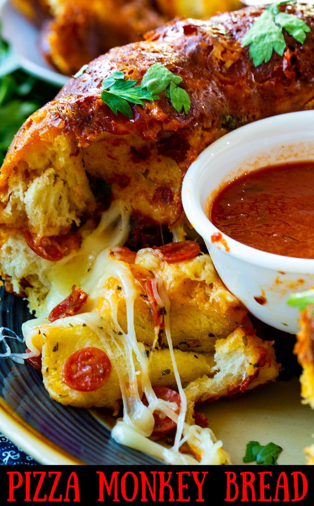 Pizza Monkey Bread on a plate with bowl of marinara sauce.