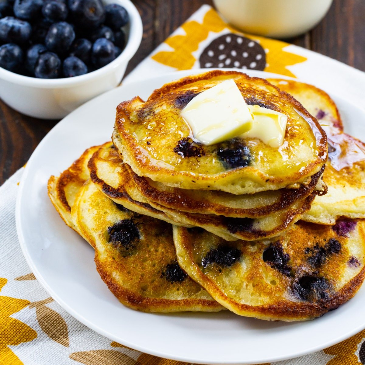 Sour Cream Blueberry Pancakes stacked on a plate.