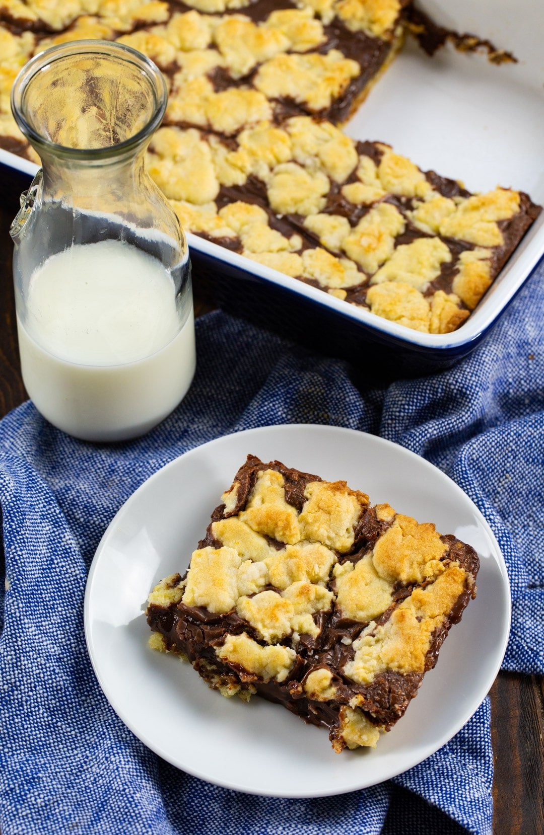 Cake Mix Bar on plate, glass of milk, and bars in baking dish.