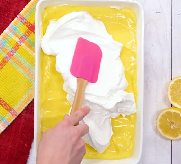 Spreading Cool Whip on top.