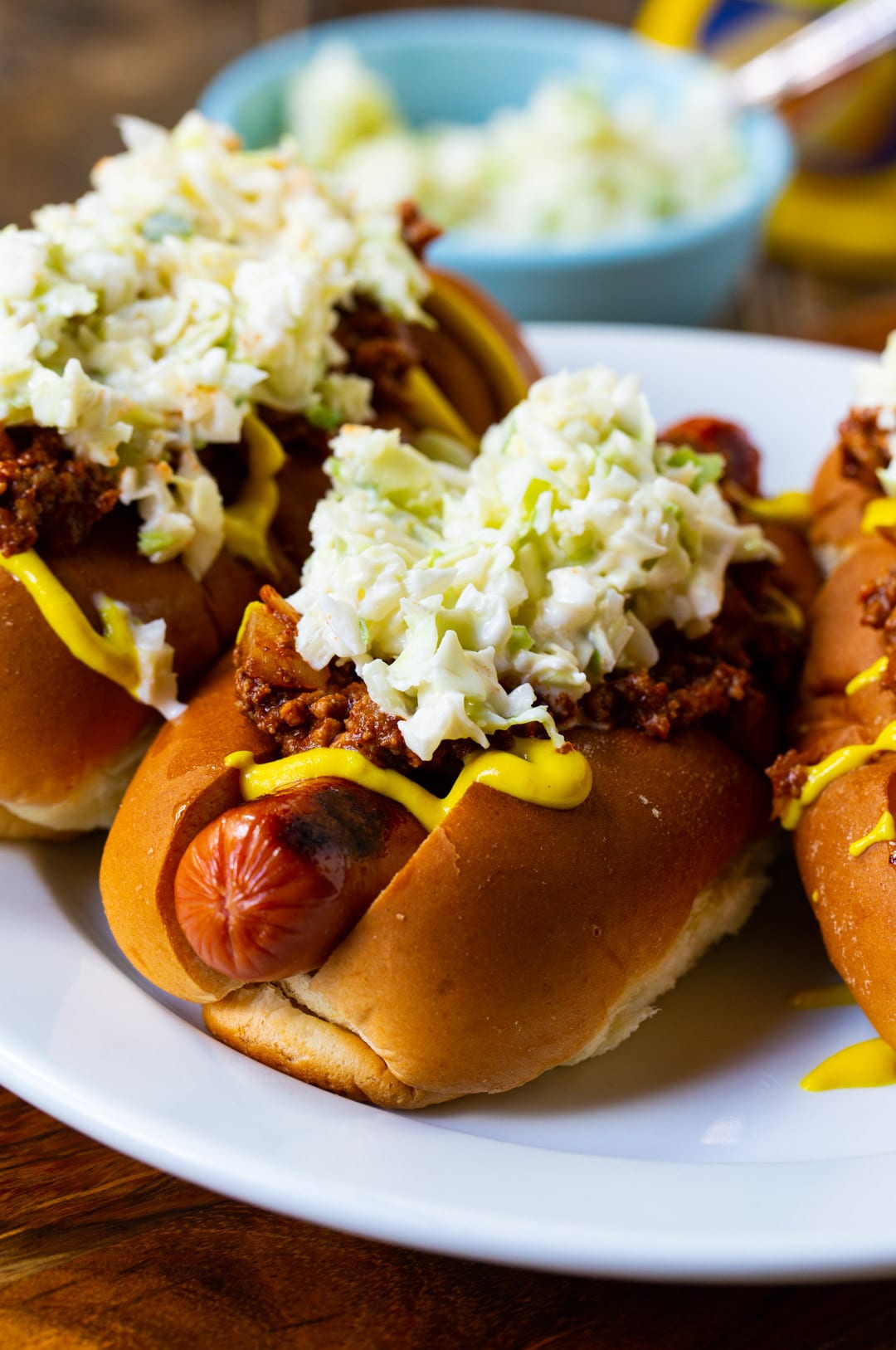 Three Chili Slaw Dogs on a plate.