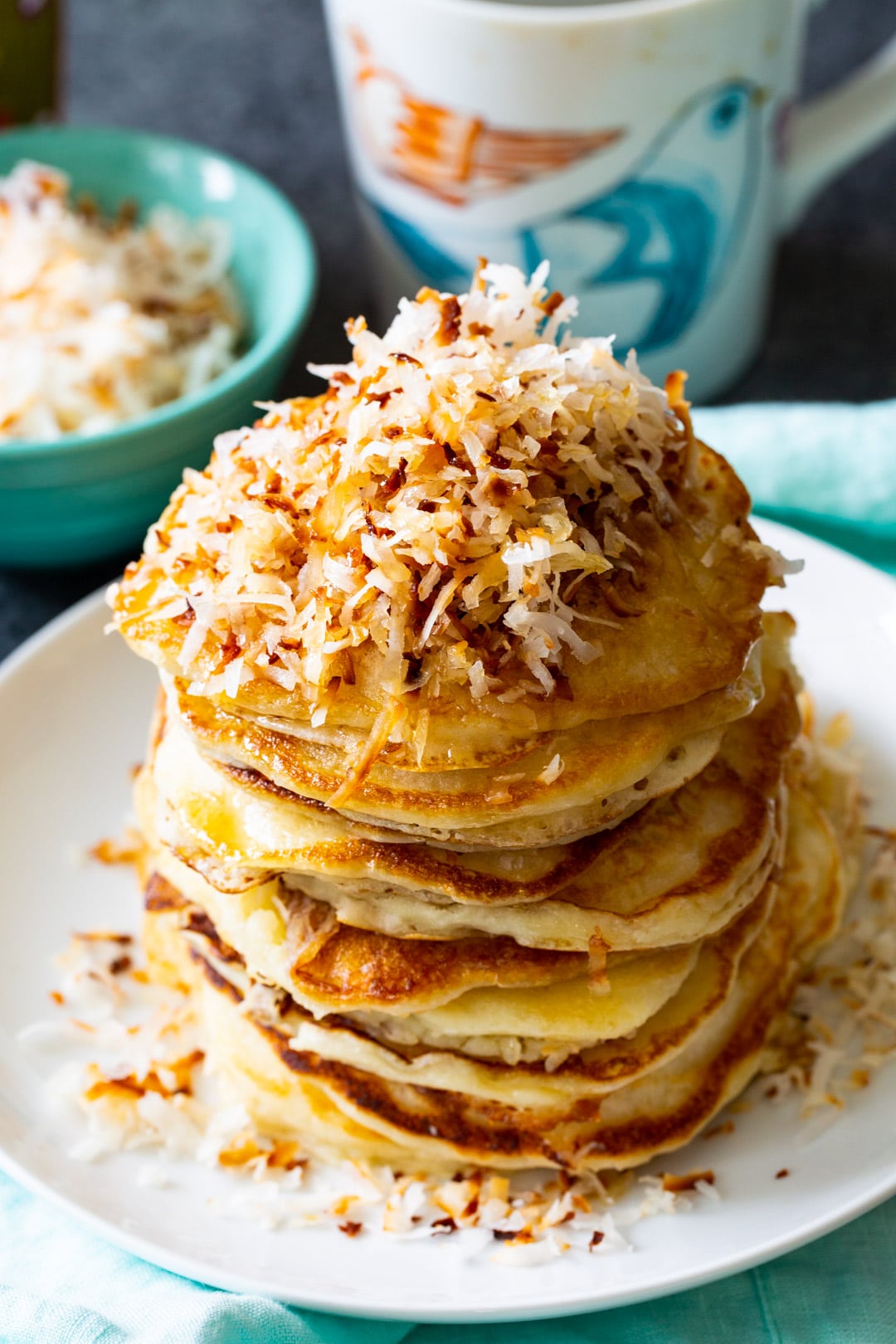 Stack of pancakes topped with toasted shredded coconut.