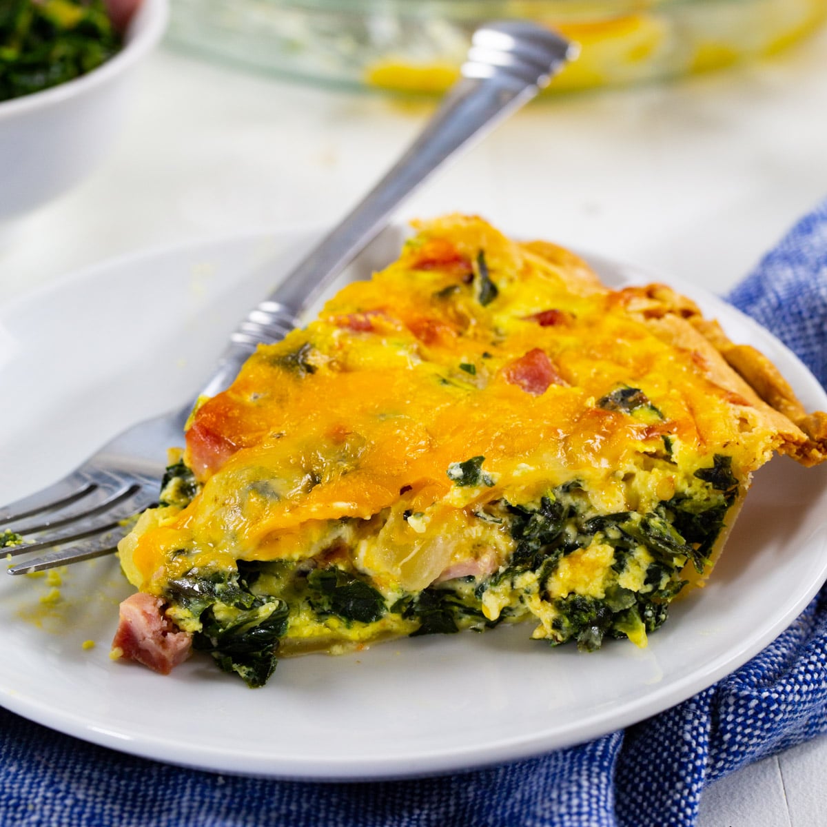 Slice of Collard Greens Quiche on a plate.