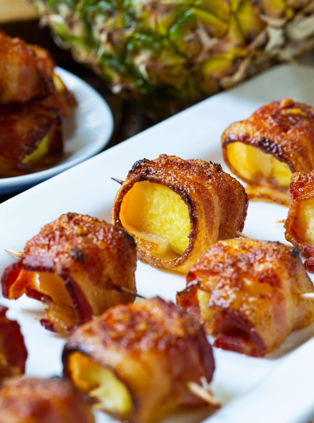 Spicy Bacon Wrapped Pineapple Bites on a serving tray.