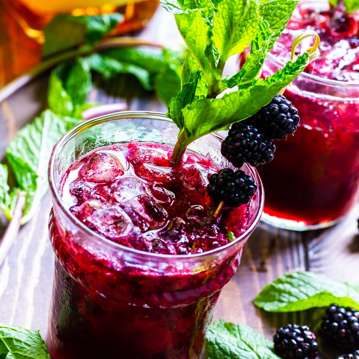 Blackberry Mint Juleps in glasses with fresh mint.