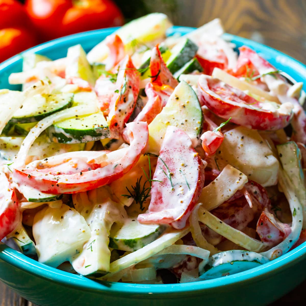 Creamy Tomato and Cucumber Salad in a blue serving bowl.