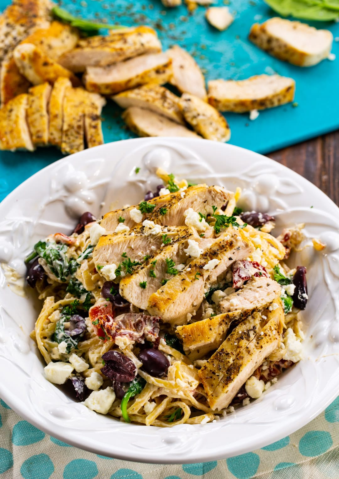 Greek Pasta with sliced chicken in background.