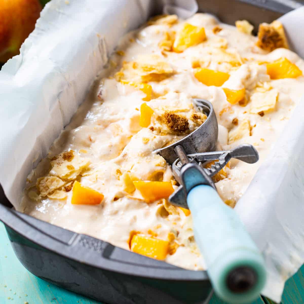 Peach Cobbler Ice Cream in 9x5-inch dish with ice cream scoop.