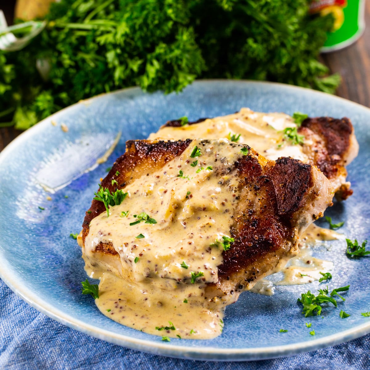 Pork Chops with Creole Mustard Sauce dished up on a plate.