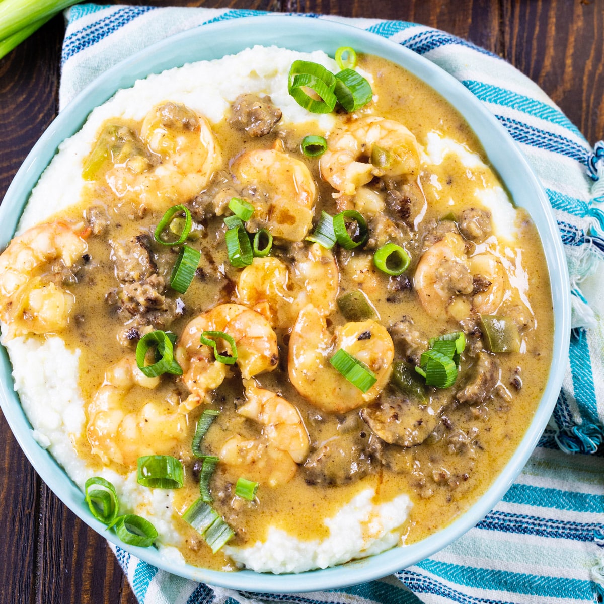 Overhead of shrimp and grits in blue bowl.