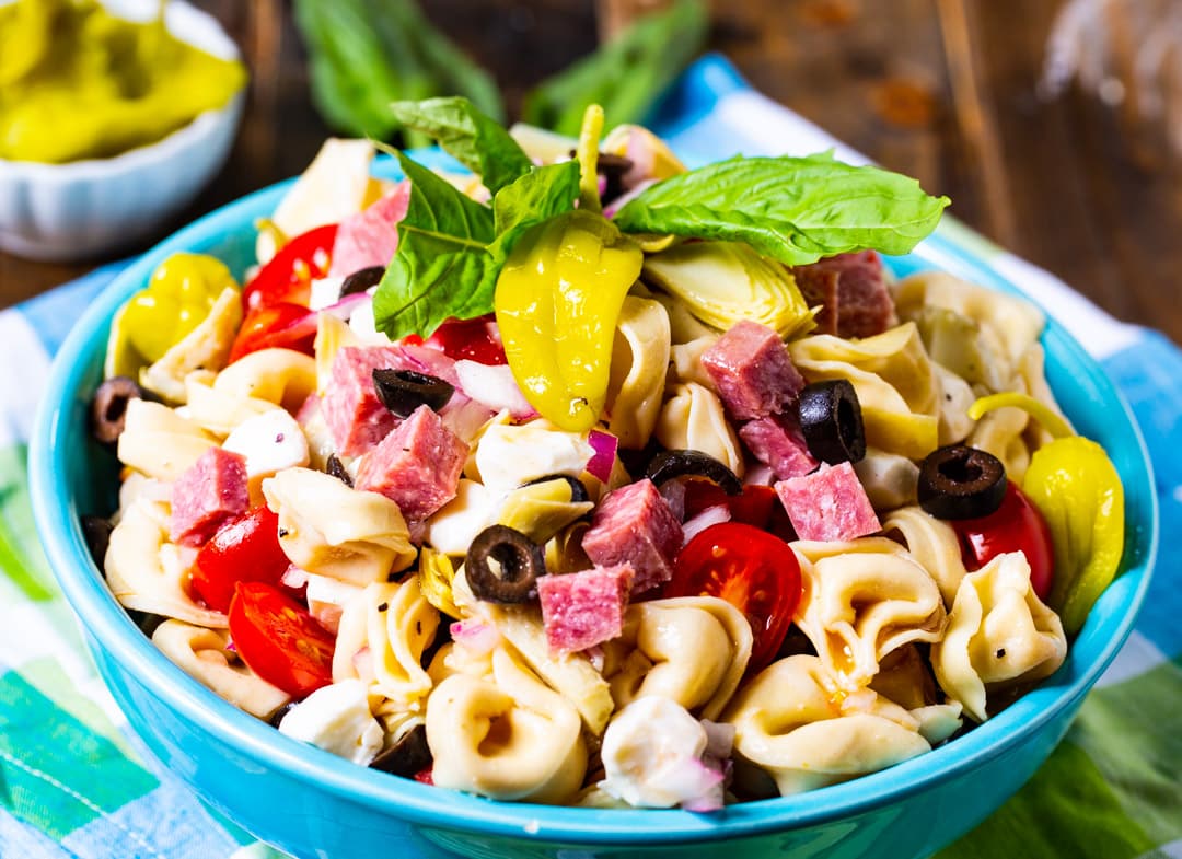 Pasta Salad topped with basil in blue bowl.