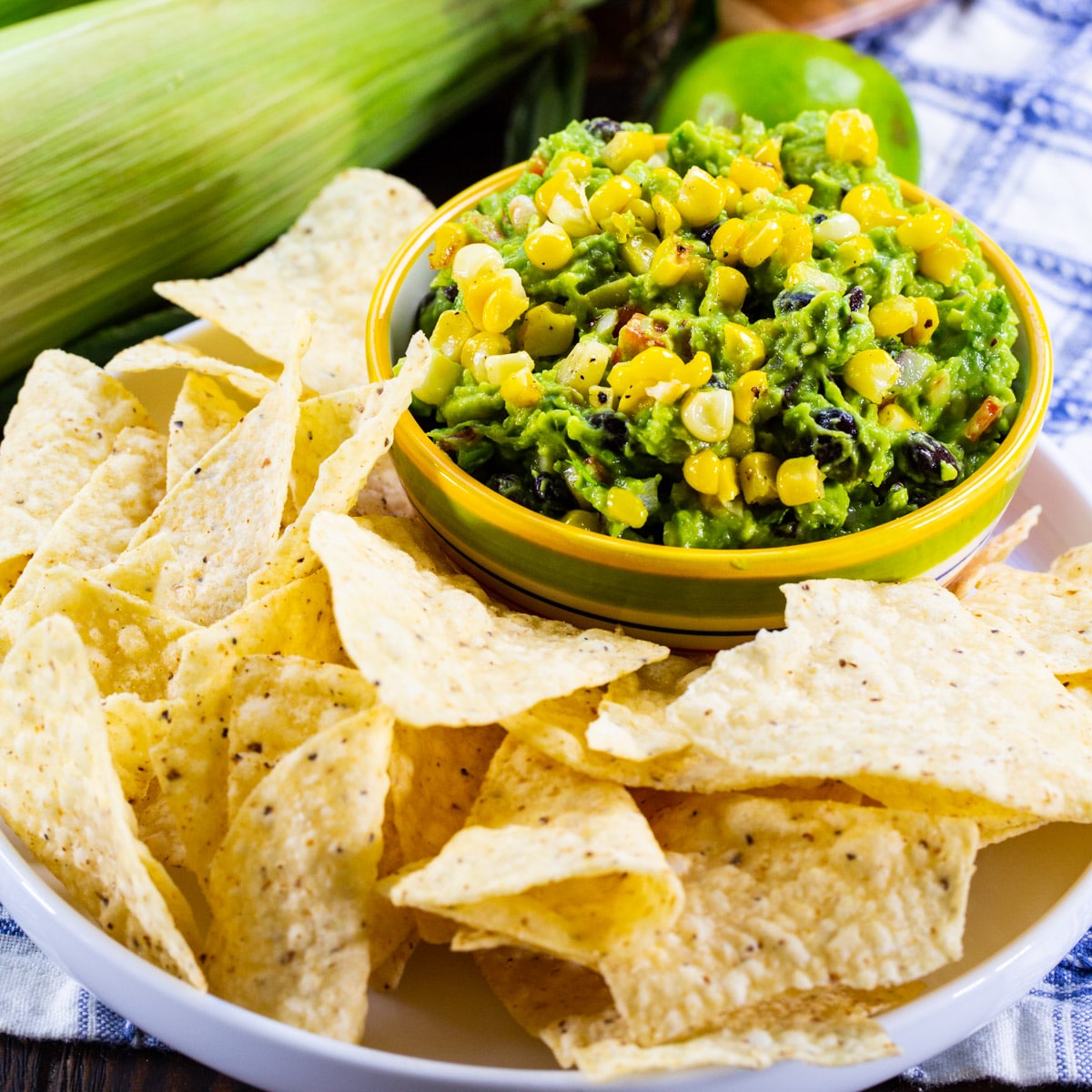 Black Bean and Corn Guacamole in a bowl surrounded by chips.
