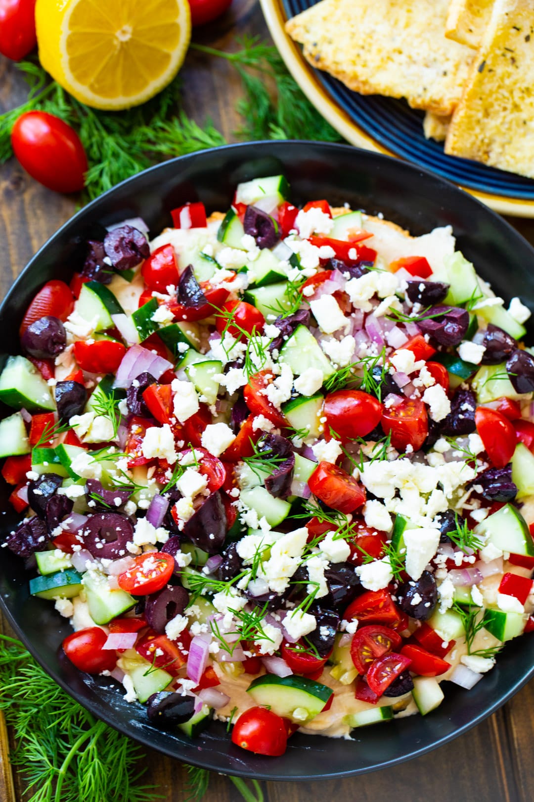 Greek Dip in bowl and pita chips on plate.