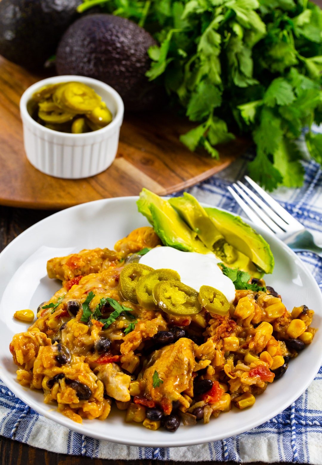 Mexican Casserole on a plate with sliced avocado.
