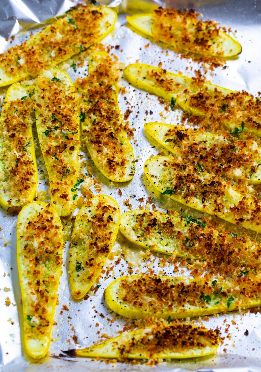 Squash slices topped with panko crumbs on baking sheet.