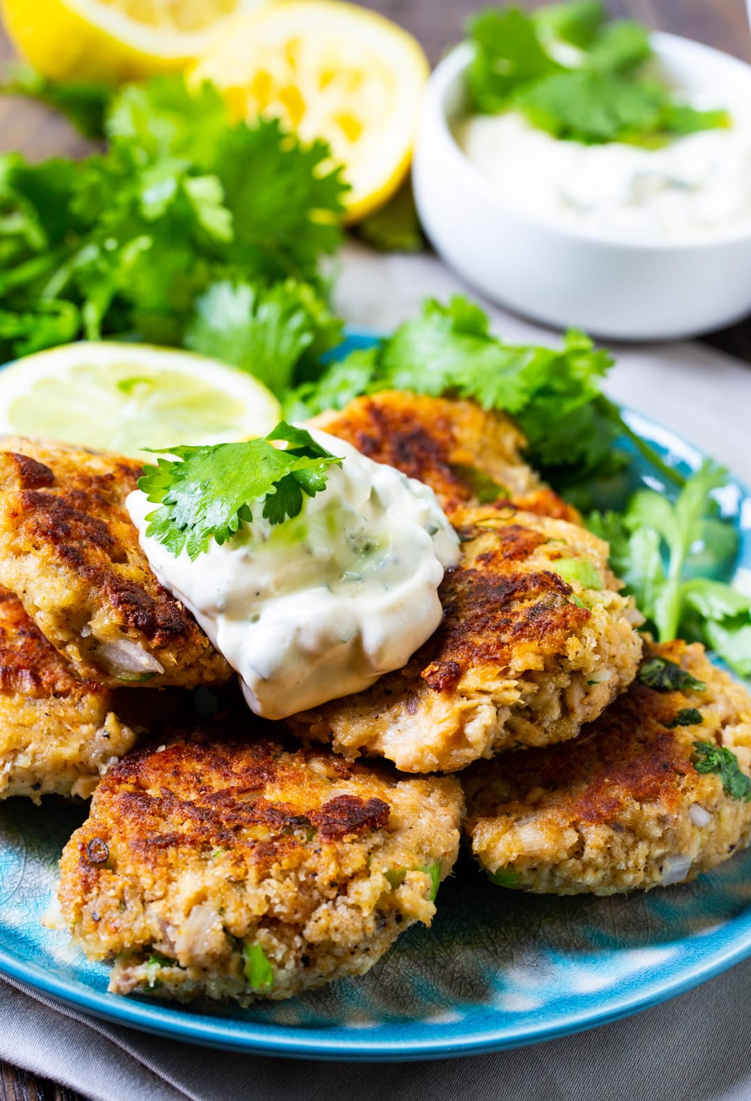Salmon Croquettes plied on a plate and topped with cilantro mayonnaise.