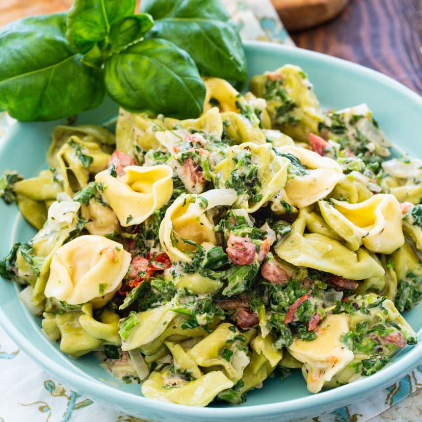 Creamy Spinach Tortellini in blue bowl.