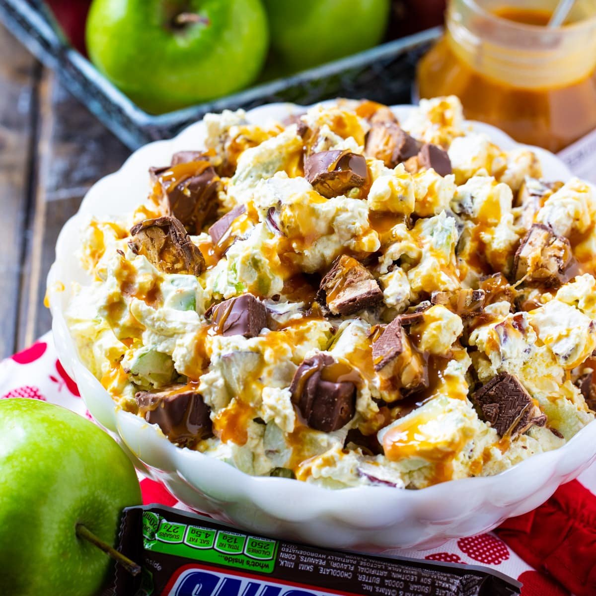 Snickers Caramel Apple Salad in a white serving bowl.