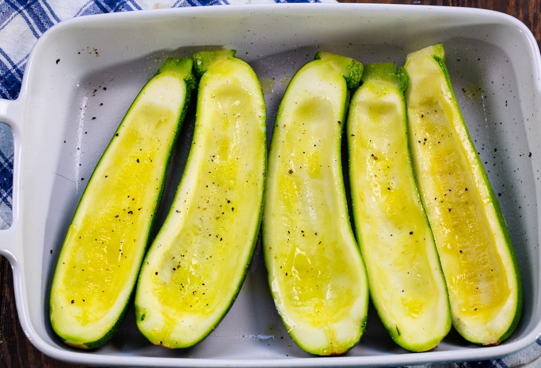 Hollowed out zucchini pre-baked in baking dish.