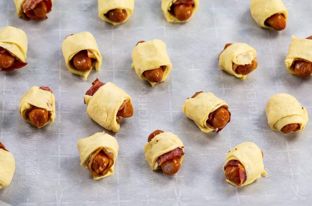Uncooked wieners wrapped in crescent dough.