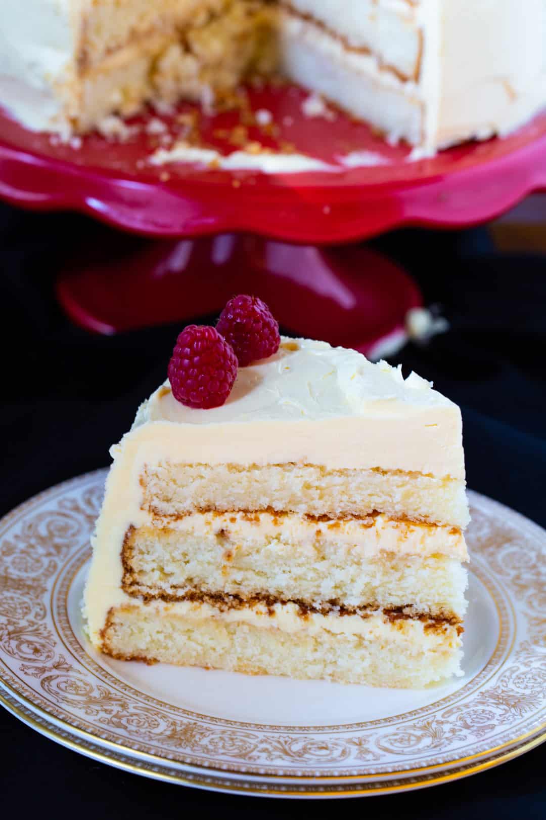 Slice of cake topped with fresh raspberries.