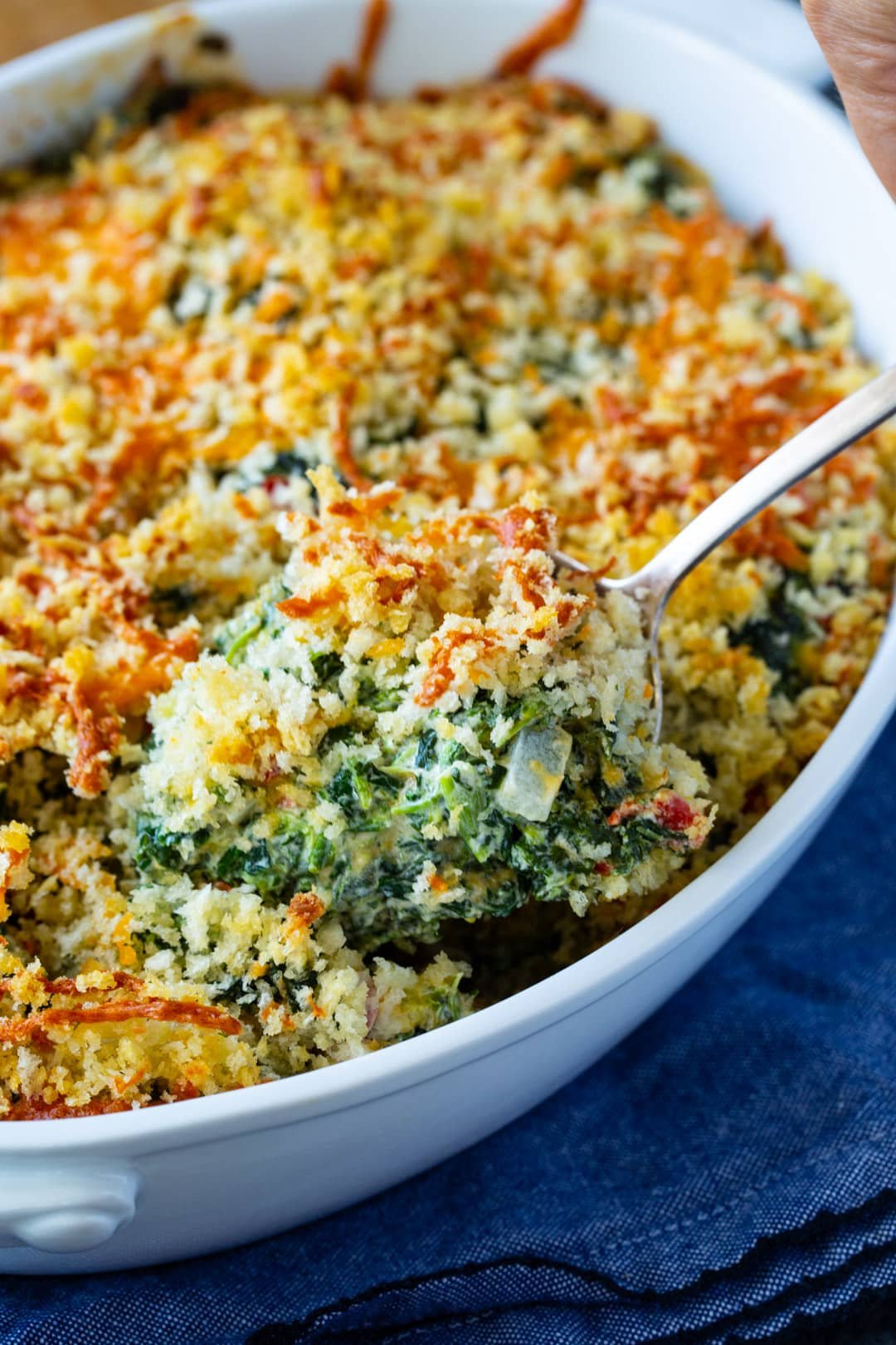 Spoon scooping up creamed spinach.