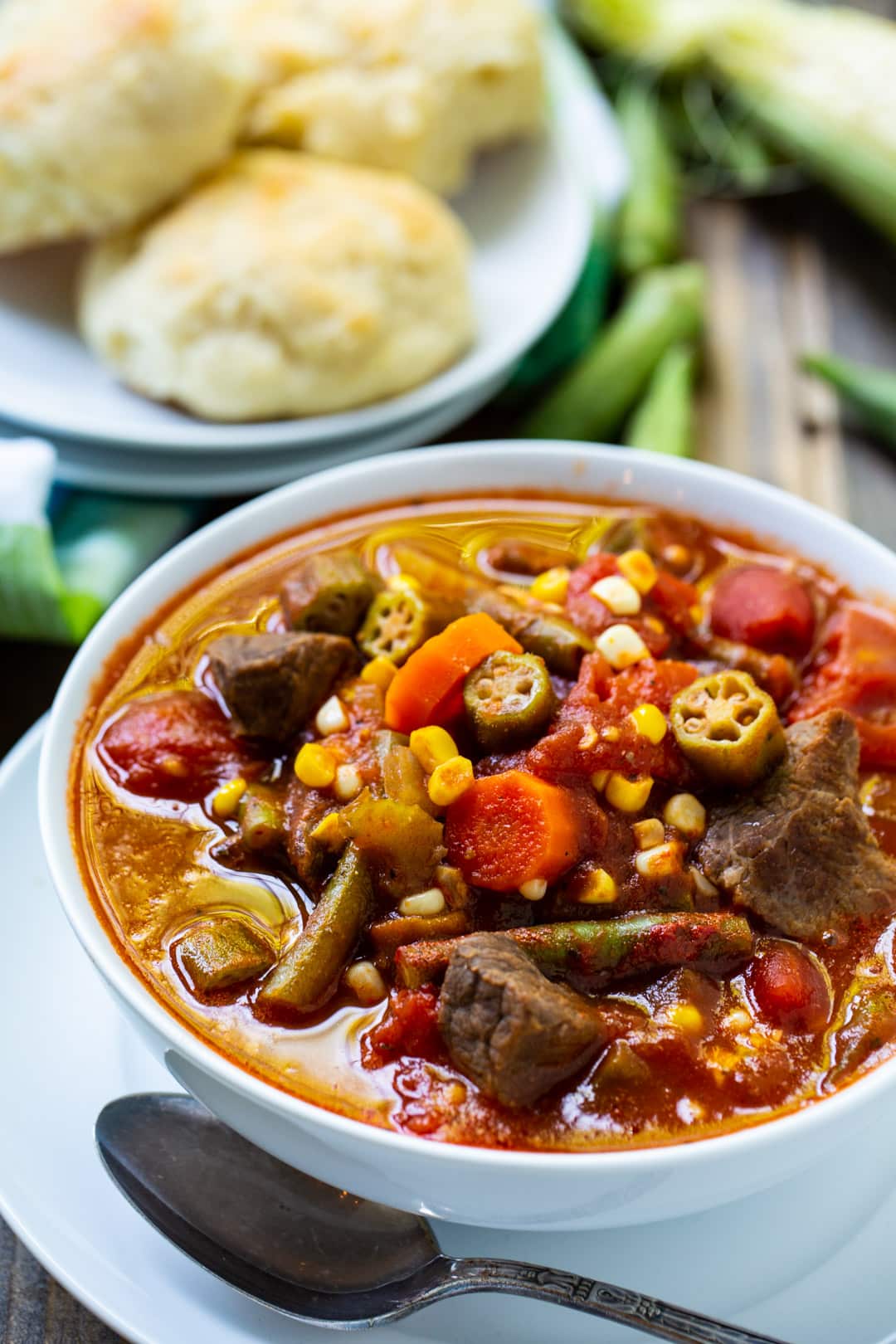 Soup in a bowl and plate of rolls.