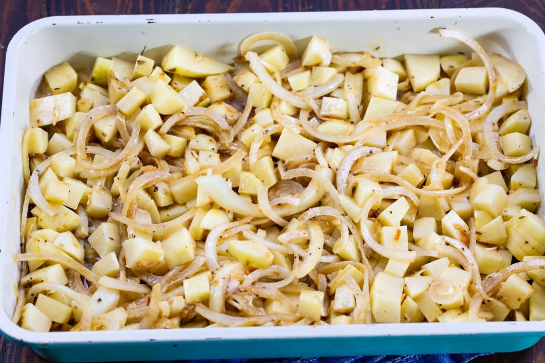 Potatoes and onions in baking dish.