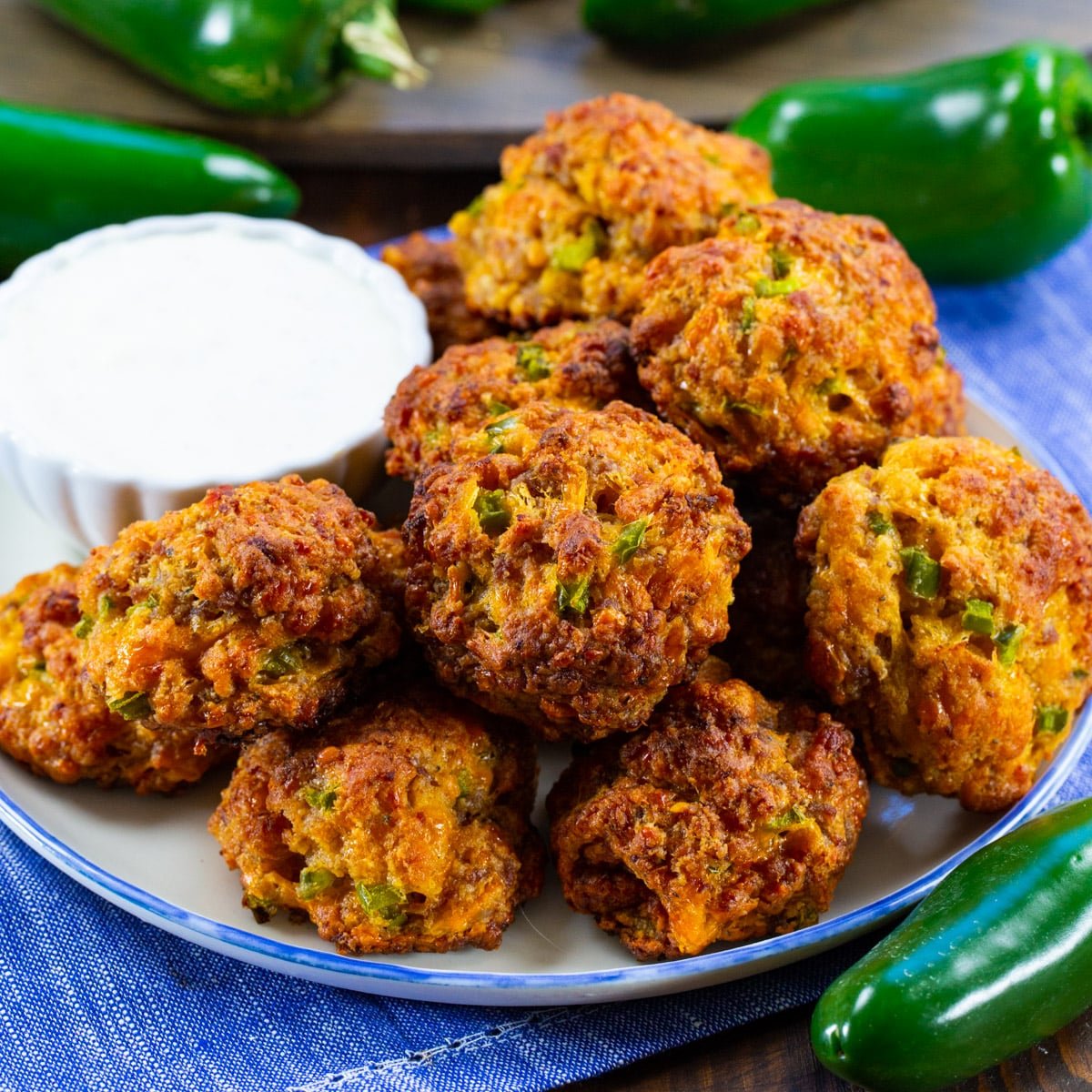 Jalapeno Sausage Balls on a plate with small bowl of ranch dip.