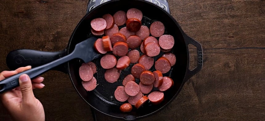 Browning the sausage in a skillet.
