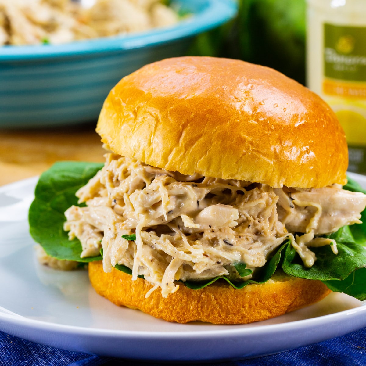 Instant Pot Caesar Chicken on a bun with lettuce.