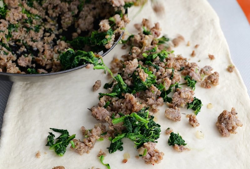Spreading filling across dough.