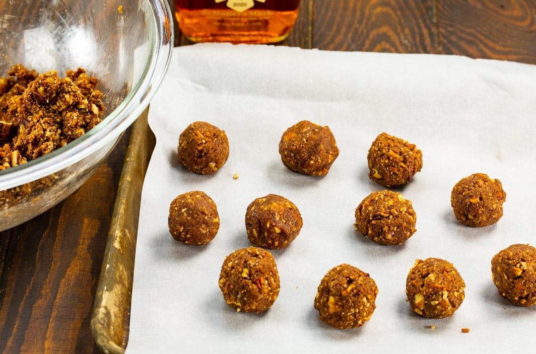Bourbon balls on a parchment paper lined tray.