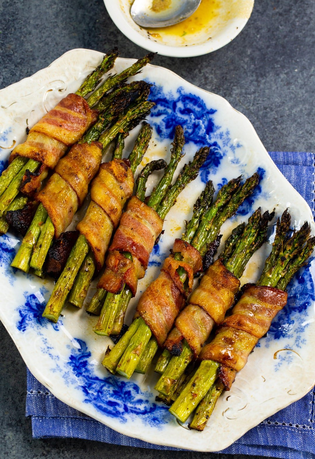 Asparagus Bundles wrapped with bacon on a plate.