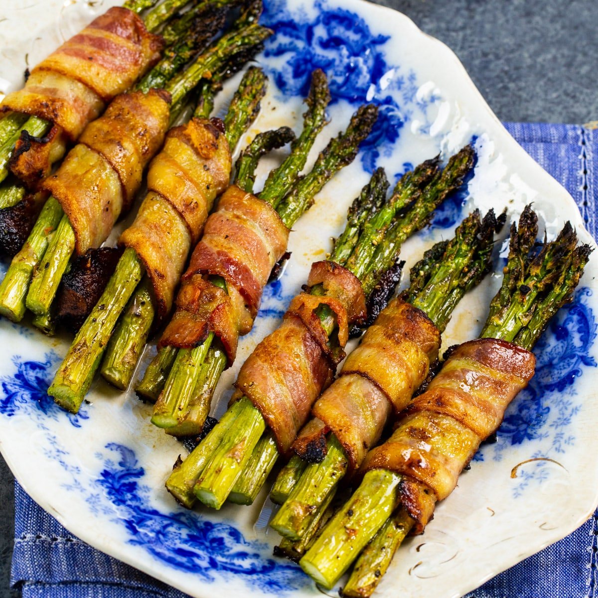 Bacon Wrapped Asparagus Bundles on a serving plate.