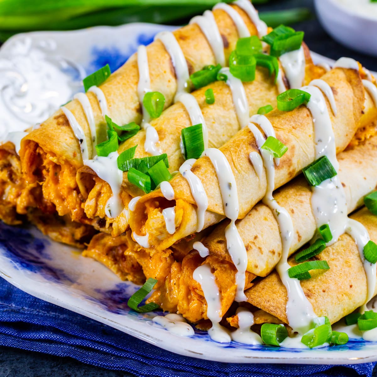 Cheesy Buffalo Chicken Taquitos piled on a plate.