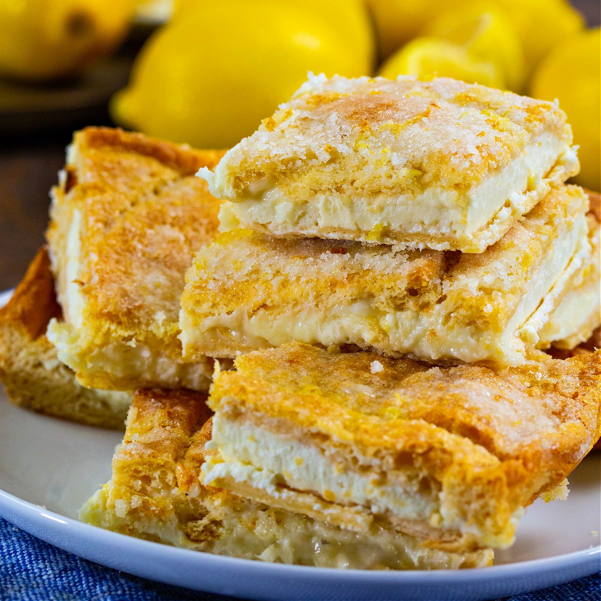 Lemon Cream Cheese Bars stacked connected  a plate.