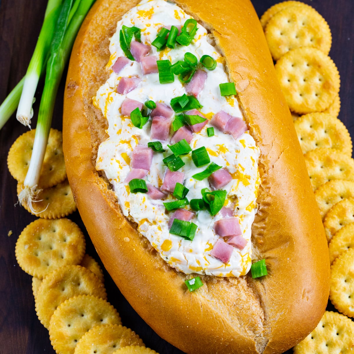 Mississippi Sin Dip in a bread bowl surrounded by crackers.