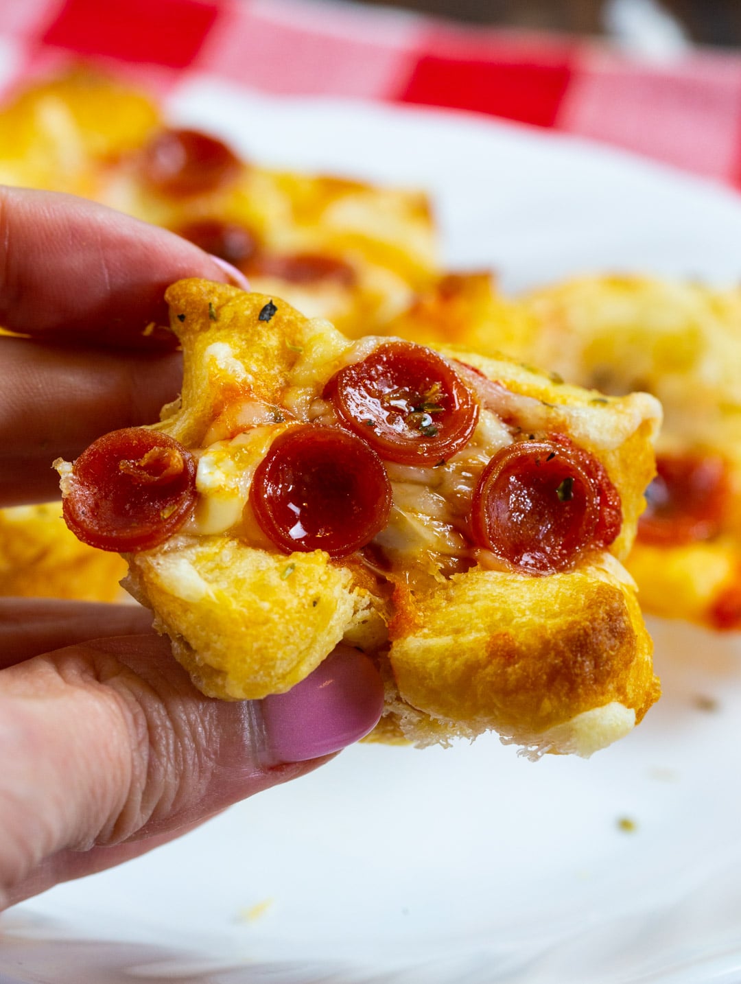 Hand holding a Pepperoni Pizza Popper.