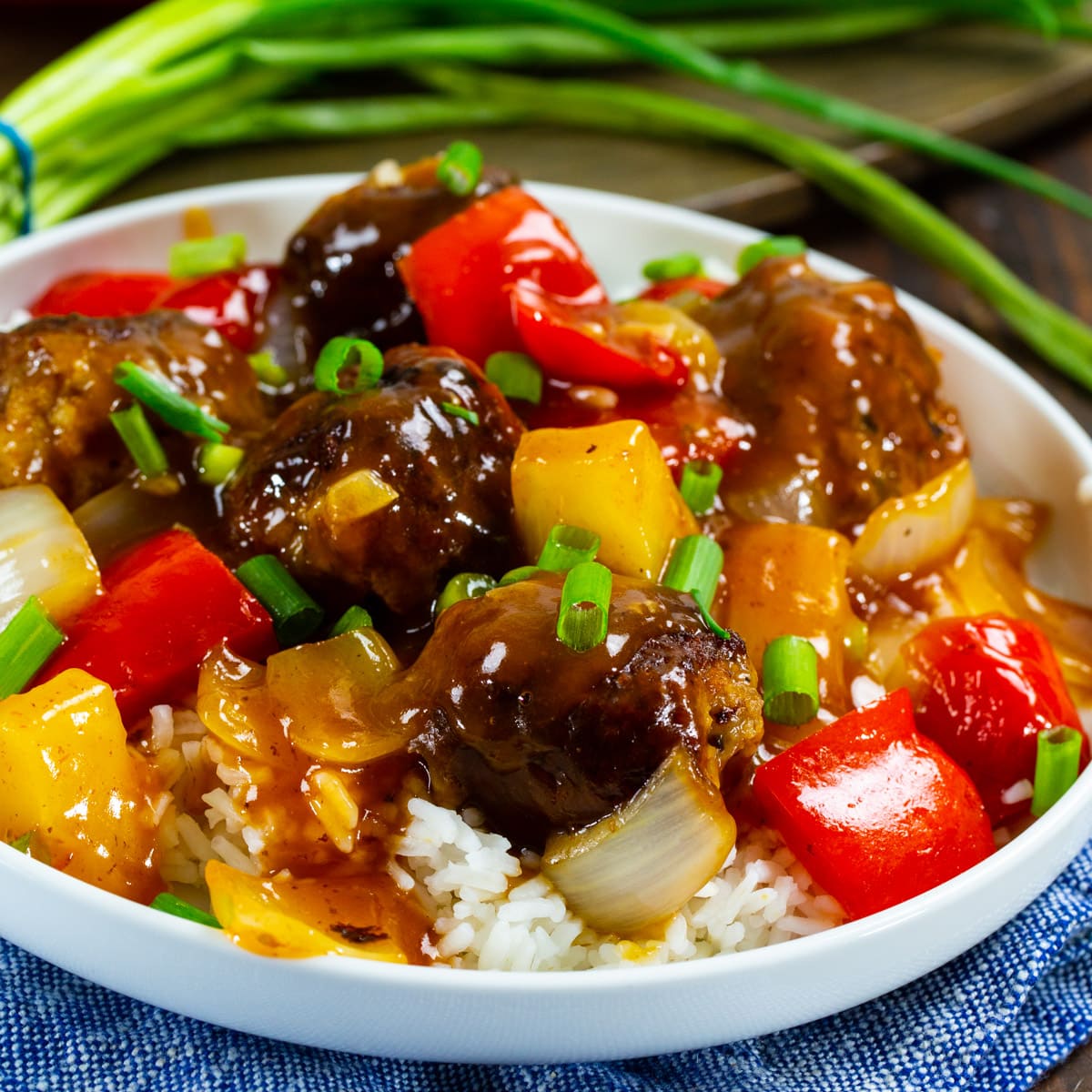 Sweet and Sour Meatballs over rice on a plate.