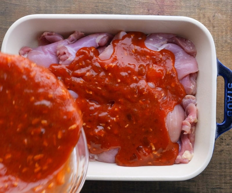 Pouring glaze over chicken.