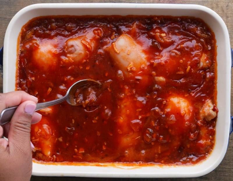 Spooning glaze over chicken.